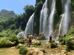 A group of four people enjoying the lush greenery and cascading waterfalls of a scenic Vietnamese nature spot.